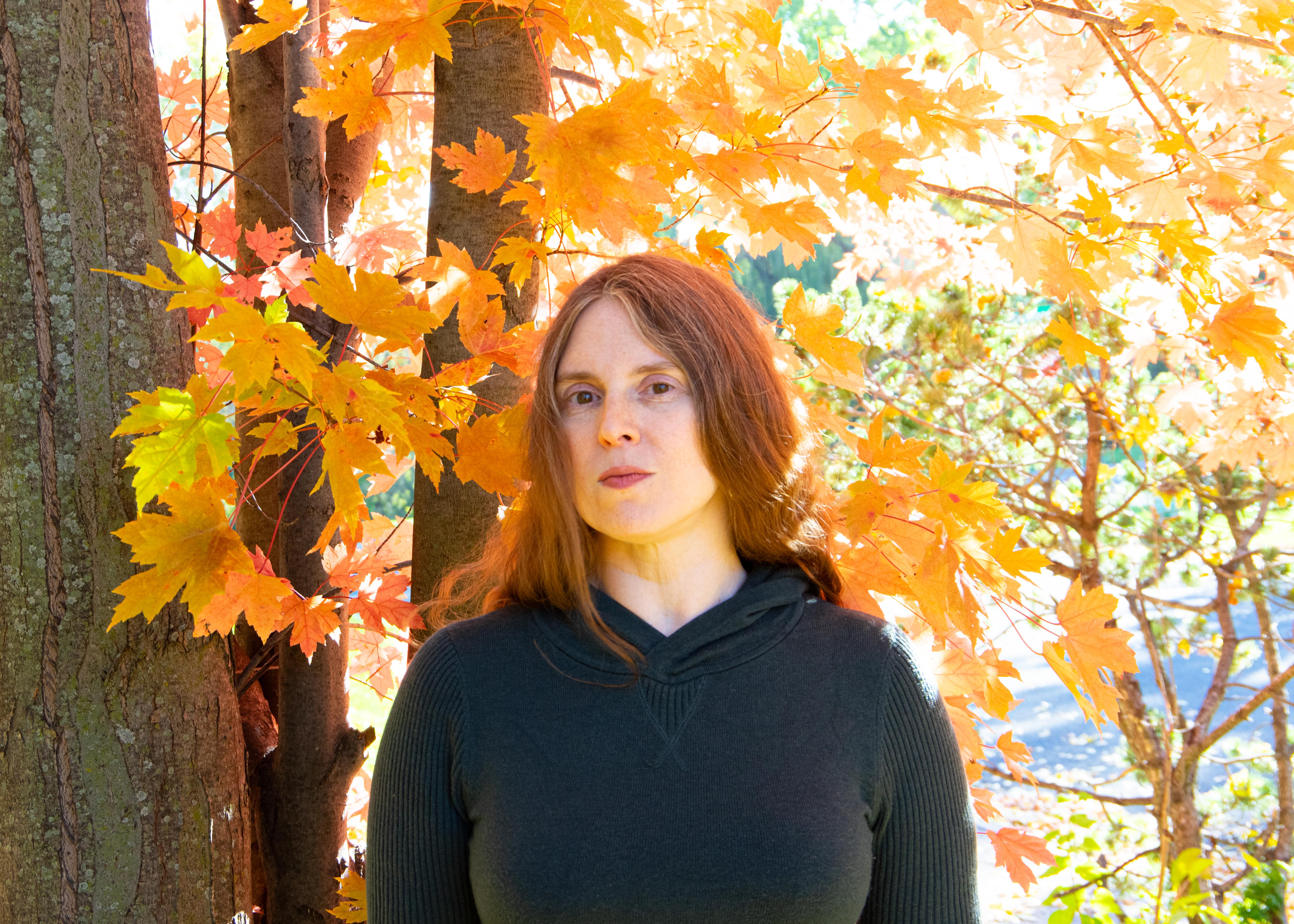 the author standing in front of fall foliage